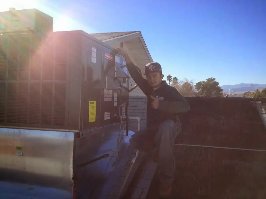 HVAC technician performing HVAC Inspection on a rooftop unit in Bastrop